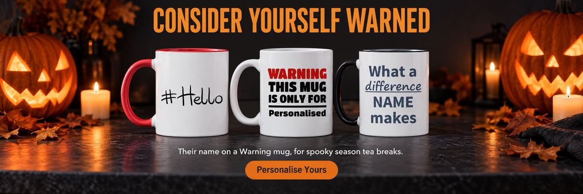 Consider Yourself Warned. Their name on a Warning mug, for spooky season tea breaks. Personalise Yours. Hashtag, Warning and What a Difference personalised mugs on a dark counter beside glowing jack-o'-lanterns.