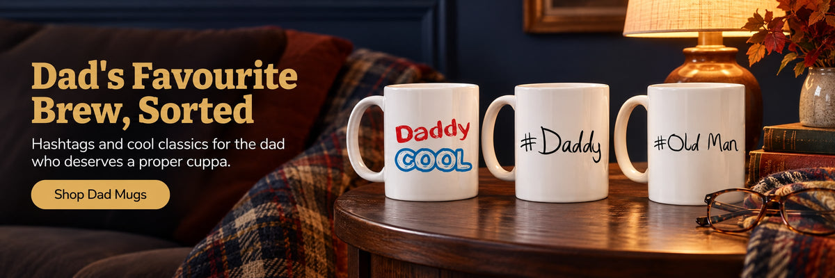 Dad's Favourite Brew, Sorted. Hashtags and cool classics for the dad who deserves a proper cuppa. Shop Dad Mugs. Three dad mugs on a walnut side table with a plaid throw and reading glasses in lamplight.